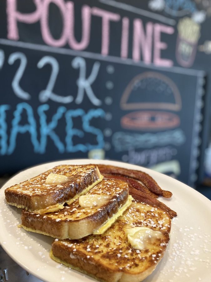 French toast dusted with icing sugar, served with bacon