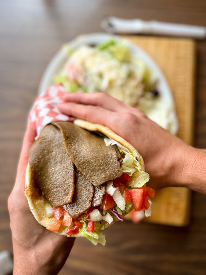 Gyro sandwich with shaved beef gyro, lettuce, tomato and onion in grilled pita
